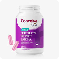 Conceive Plus Fertility Supplement For Women, showing a white and purple bottle labeled “Fertility Support Conception Multivitamin” with two pink vegan capsules displayed in front, designed to support women’s fertility and reproductive health.